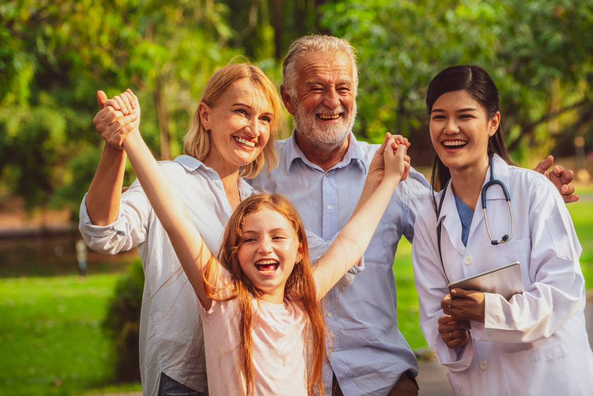 Happy healthy family and doctor talking in park.